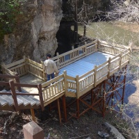 The overlook at the bottom of the Interpretive Loop Trail at Grand Gulf State Park is one of four that were recently replaced. Alt. Text: A wooden deck with stairs. After descending the stairs, the deck serves as an overlook provides views of a pond.