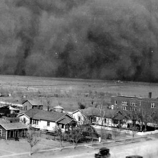 Photo of a street in Rolla, Kansas during the Dust Bowl of the 1930s with a dramatic dust cloud on the horizon.