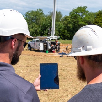 Justin Davis of the department’s Well Installation Section and a contractor with Flynn Drilling Company access well information from the WISDIM application while on site.