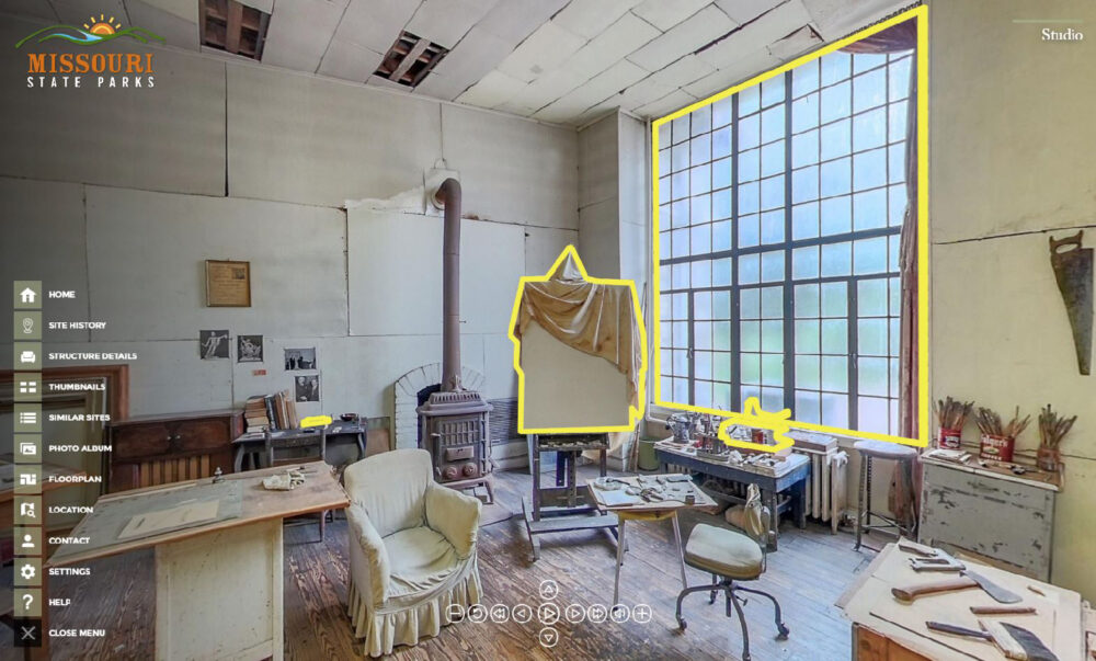 A screenshot of the virtual tour application. The view of the studio features a large window on the right, with a painter's canvas in the center. Overlaid on top of the image are navigation icons.