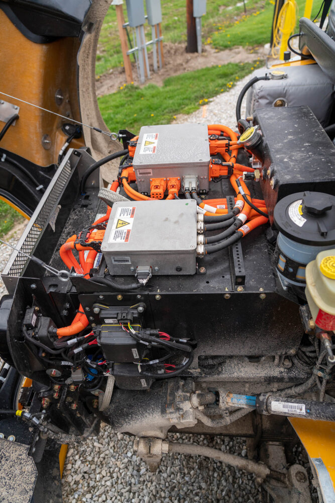 The engine compartment of a bus. Instead of a diesel engine, electric wiring fills the space.