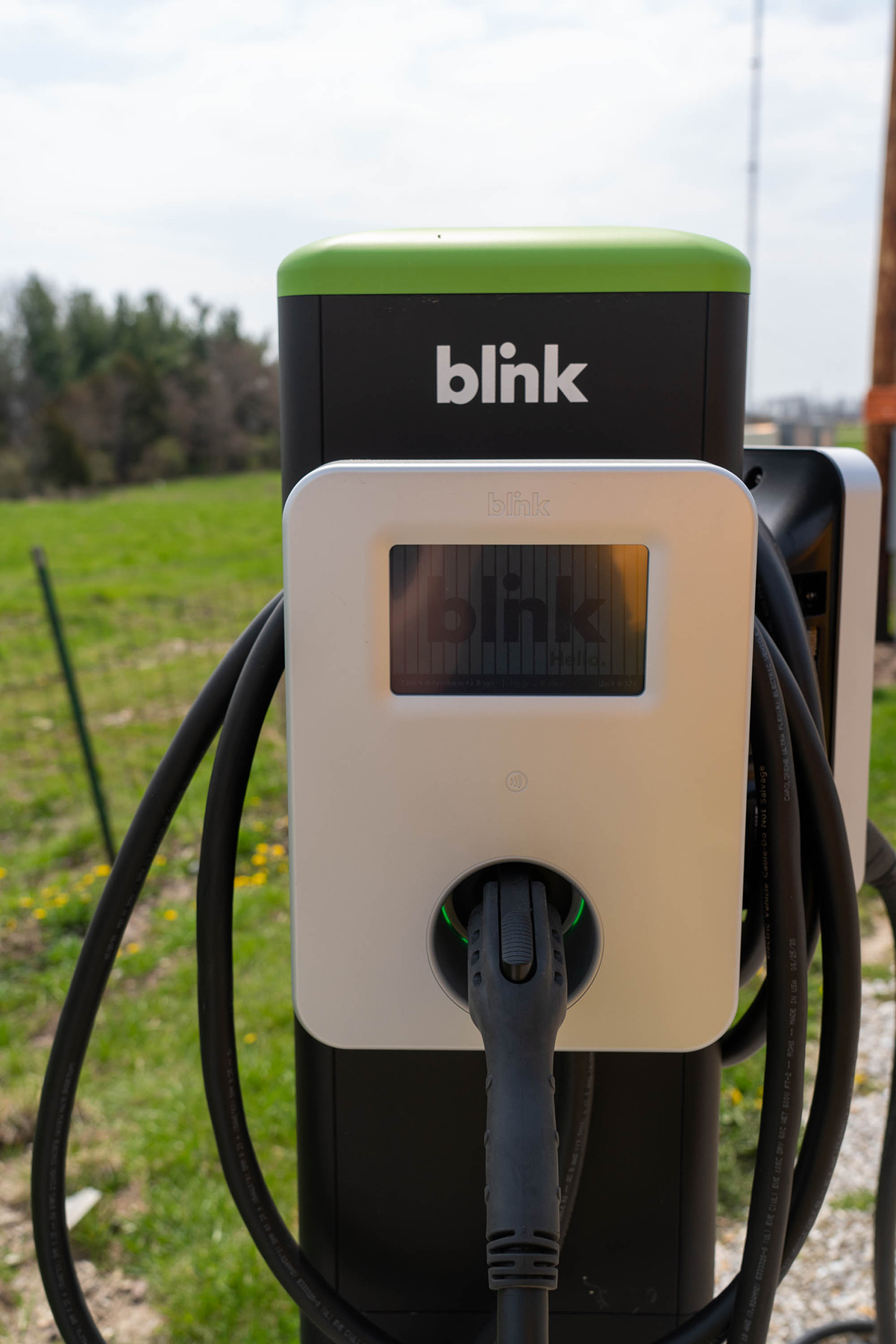 An EV charging station, similar to a gasoline pump, but instead of pumping liquid fuel, it plugs into the car's charging port and charges the battery with electricity.