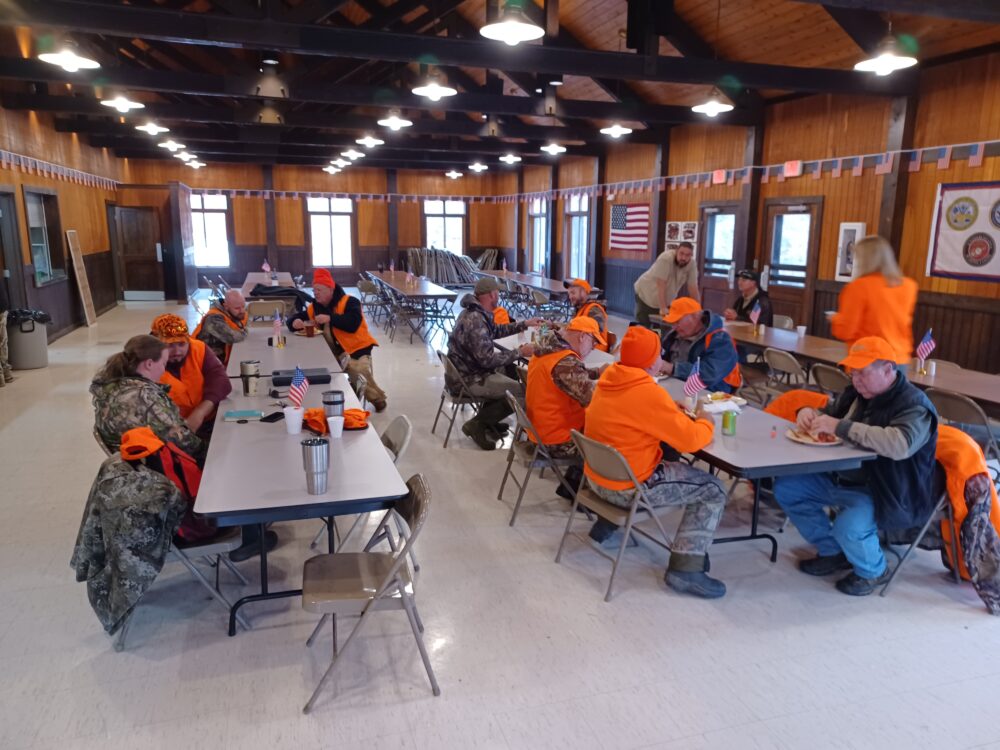 Photo of a cafeteria area filled with hunting participants eating.