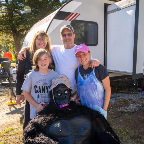 Photo of family posing around a gorilla halloween decorations.