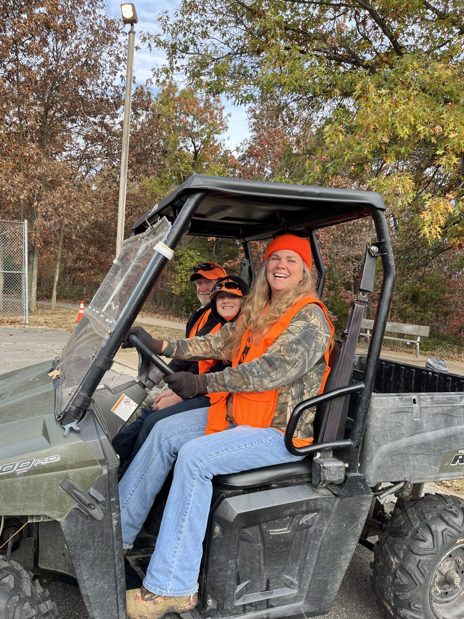 Photo of three people smiling in a Gator ATV.