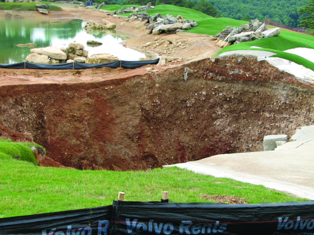 Photo of a sinkhole that has engulfed a path.