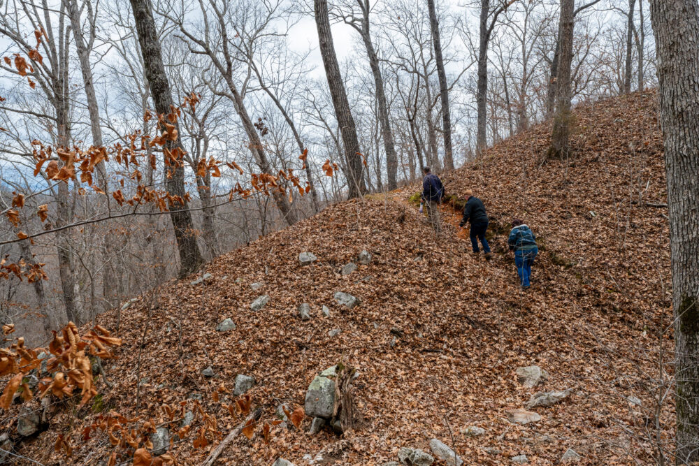 Photo of three people walking along a steep hill.