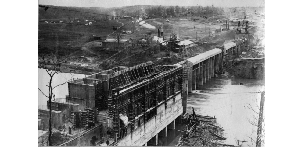 Old photo of Dam with view of lake and released water.