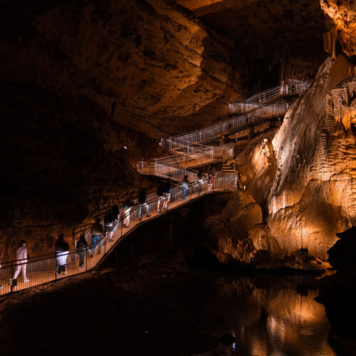 Photo of people walking along a path in a cave.