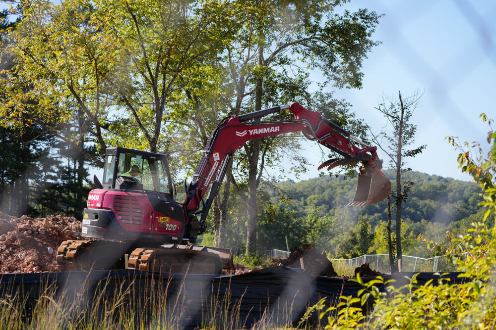 An backhoe digs out dirt at a construction site.