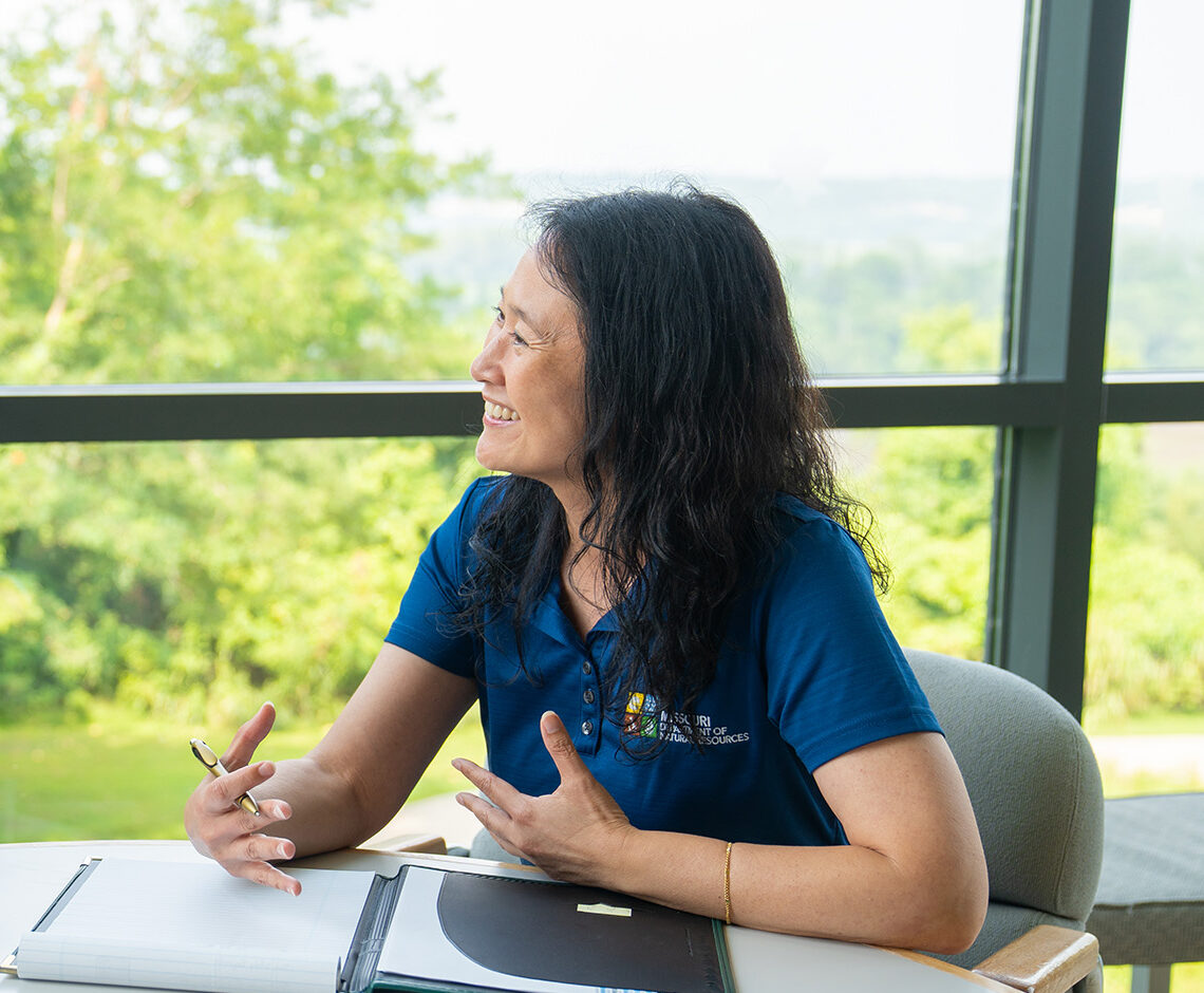 Two people sit in discussion at a round table.