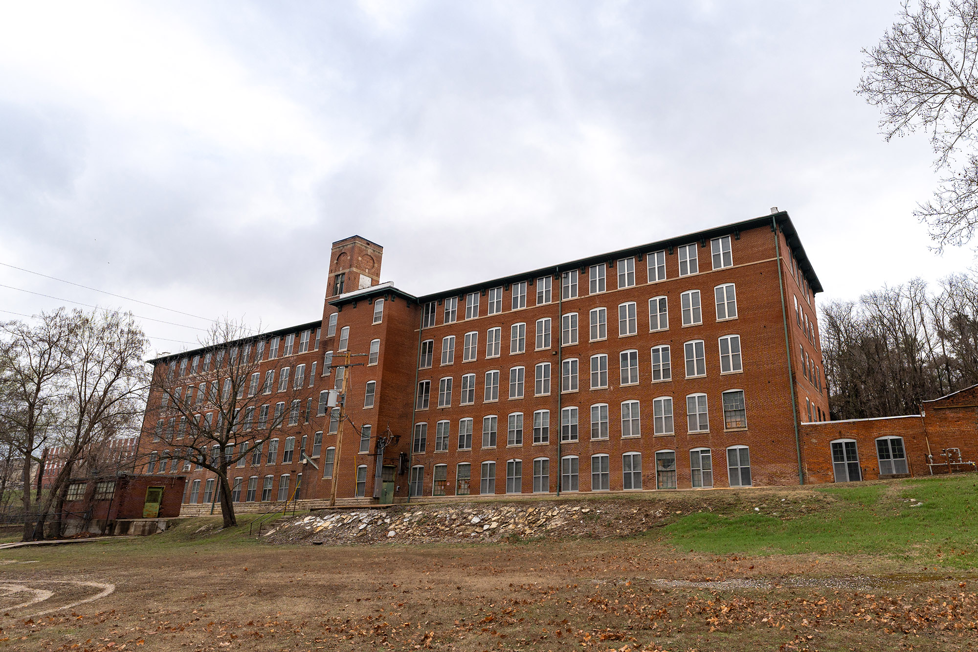 Exterior of a brick building. 5 floors all with evenly spaced large 4 pane windows.